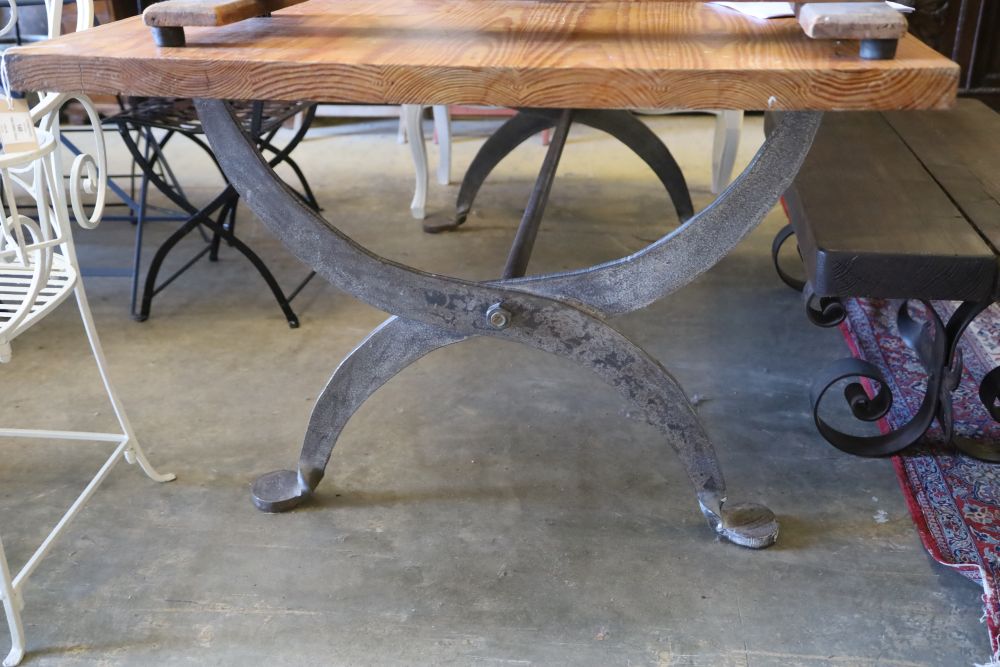 A pine dining table with wrought iron X frame base, W.200cm, D.100cm, H.78cm